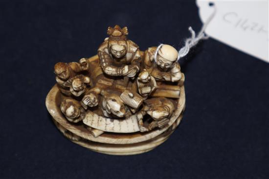 A Japanese ivory okimono netsuke of a dog with a mallet